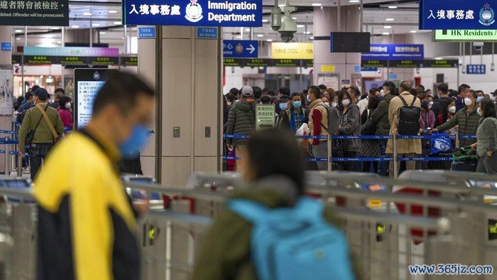 Travelers wearing face masks line up at the immigration counters of the departure hall at Lok Ma Chau station following the reopening of crossing border with mainland China, in Hong Kong, Sunday, Jan. 8, 2023. Travelers crossing between Hong Kong and mainland China, however, are still required to show a negative COVID-19 test taken within the last 48 hours, a measure China has protested when imposed by other countries. (AP Photo/Bertha Wang)